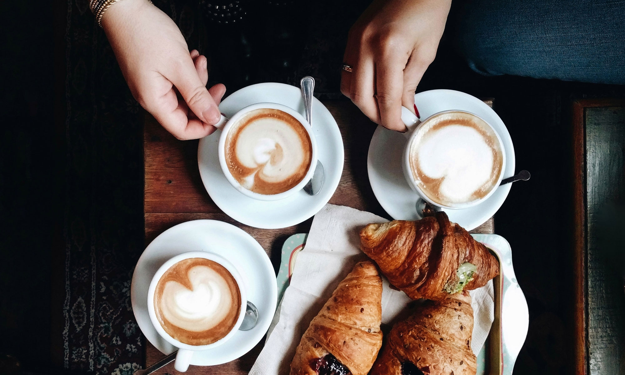 Personer fikar kaffe latte och croissanter på ett café