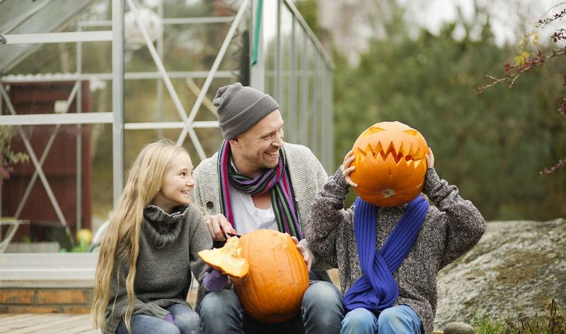 Two kids and a dad with pumpkins